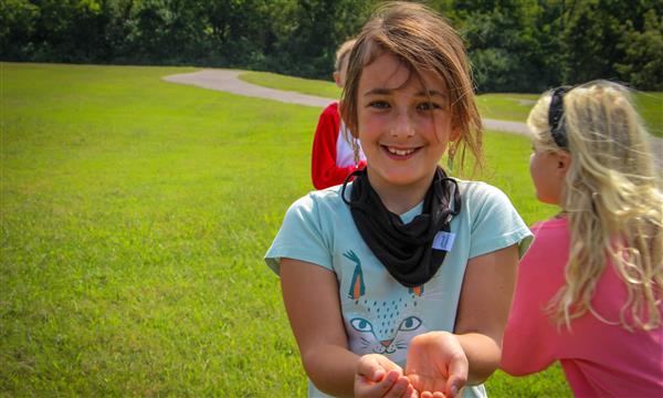 Girl holds out butterfly